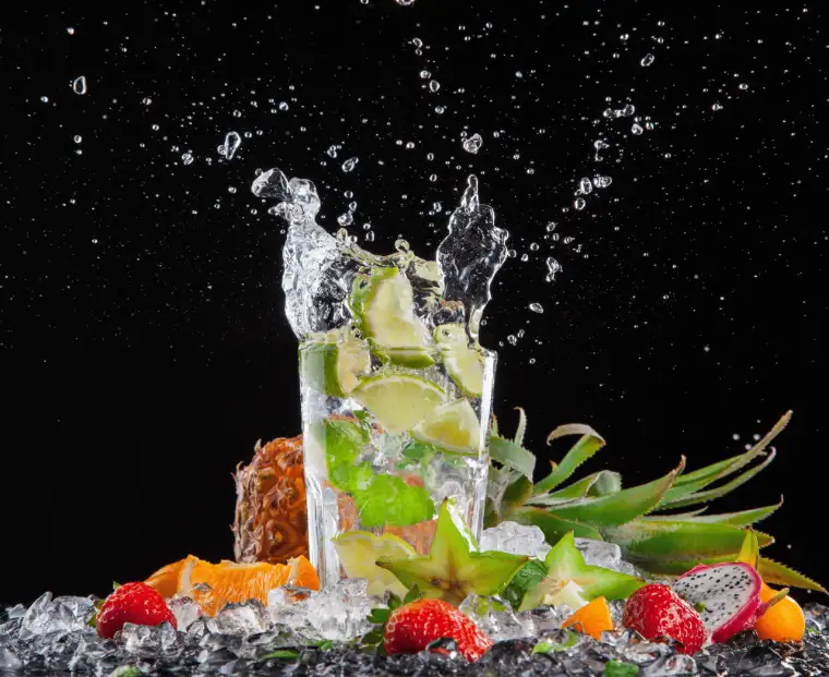Mojito with lime splashing over crushed ice